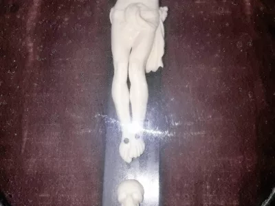 Christ en ivoire sculpté sur sa croix ou crucifix dans un cadre en bois noirci, d'époque XIXème siècle