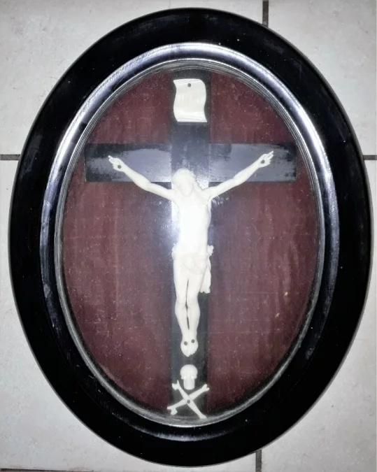 Christ en ivoire sculpté sur sa croix ou crucifix dans un cadre en bois noirci, d'époque XIXème siècle